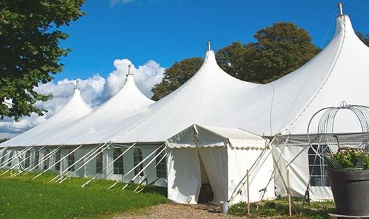 tall green portable restrooms assembled at a music festival, contributing to an organized and sanitary environment for guests in Acushnet